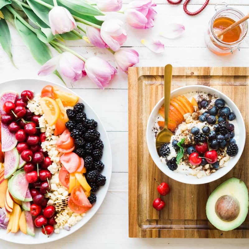 large platter of different fruits and acai bowl